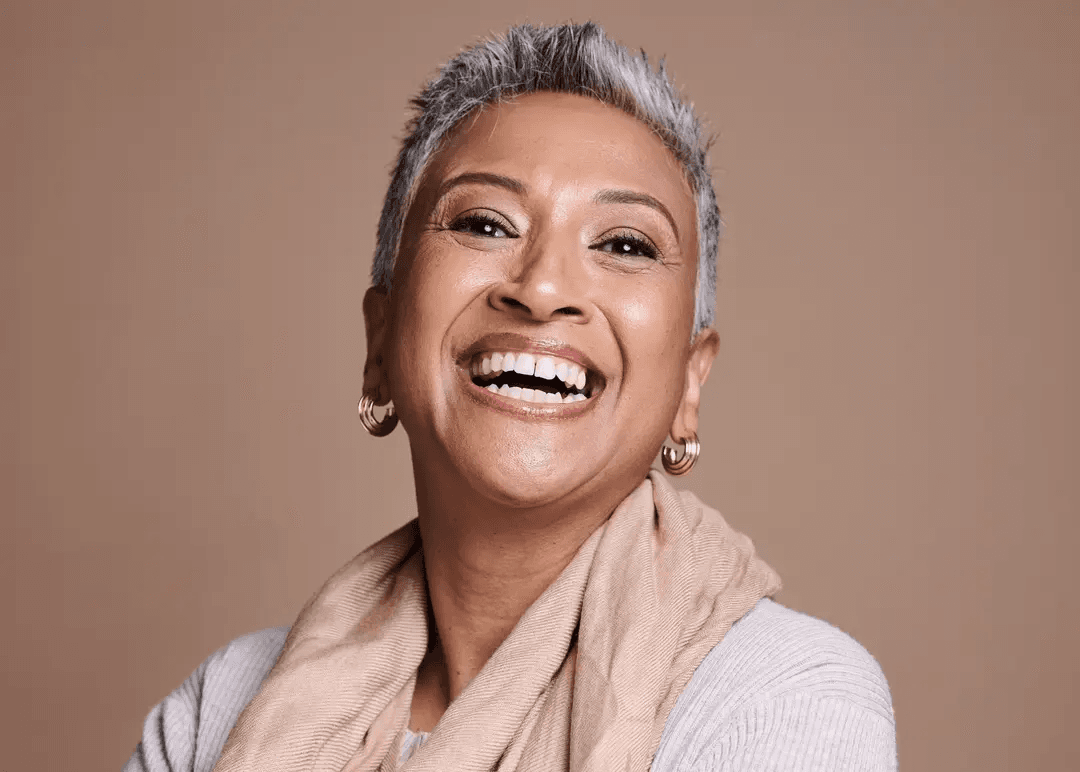 Woman with a full, confident smile after dental bridge treatment