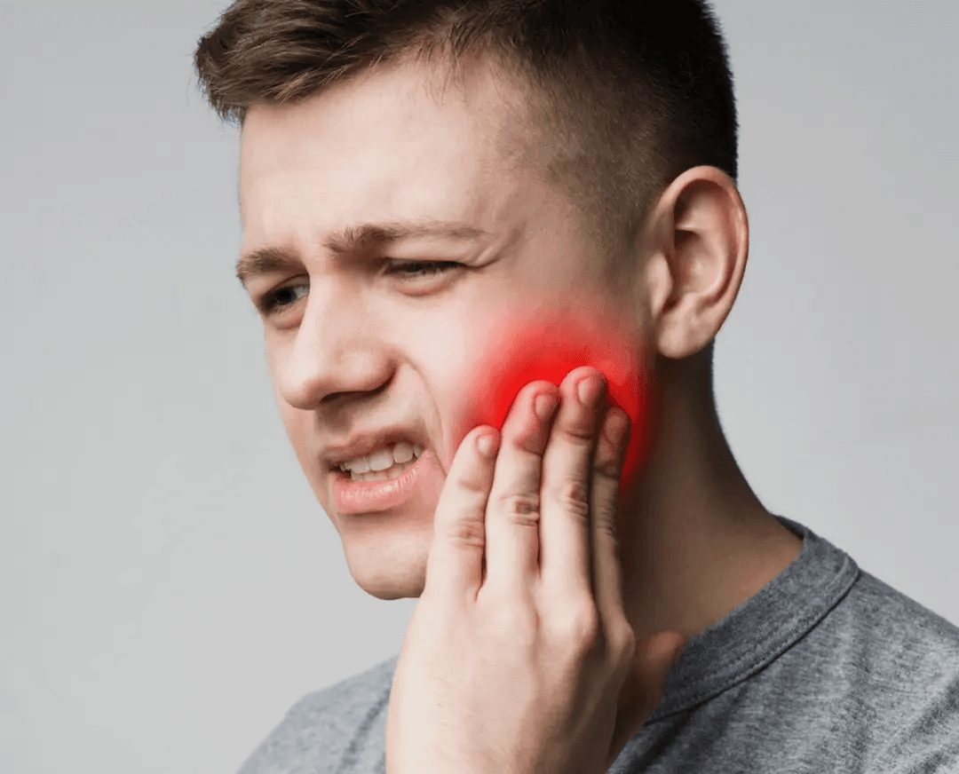 Man holding his cheek in pain from a severe toothache needing emergency dental care