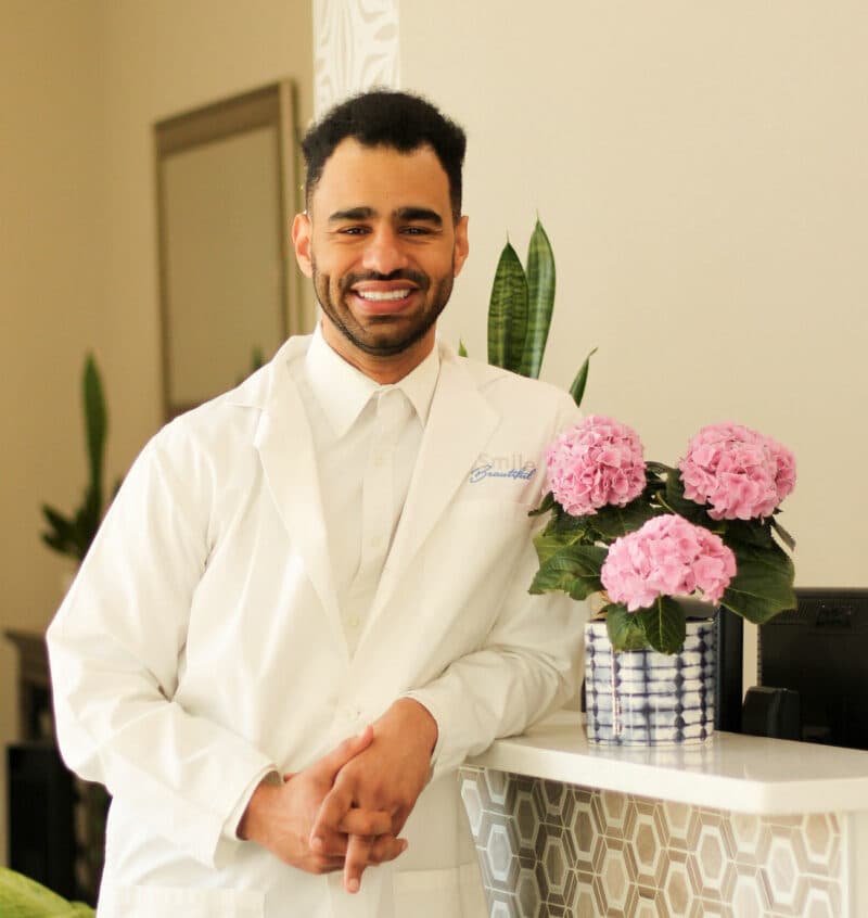 Dr. Justin “JJ” Jones, D.D.S., in his white coat at Smile Beautiful Dental