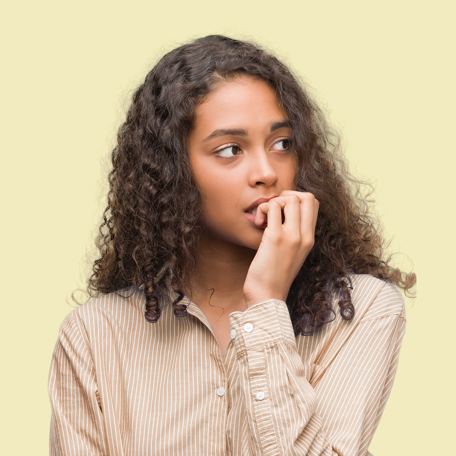 Young hispanic business woman looking stressed and nervous with hands on mouth biting nails. Anxiety problem.